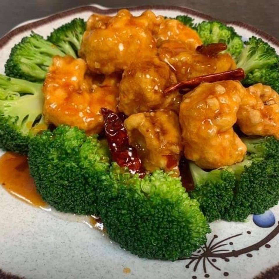 Yama Fuji's General Tso's chicken with broccoli and dried red chilies on a decorative plate.