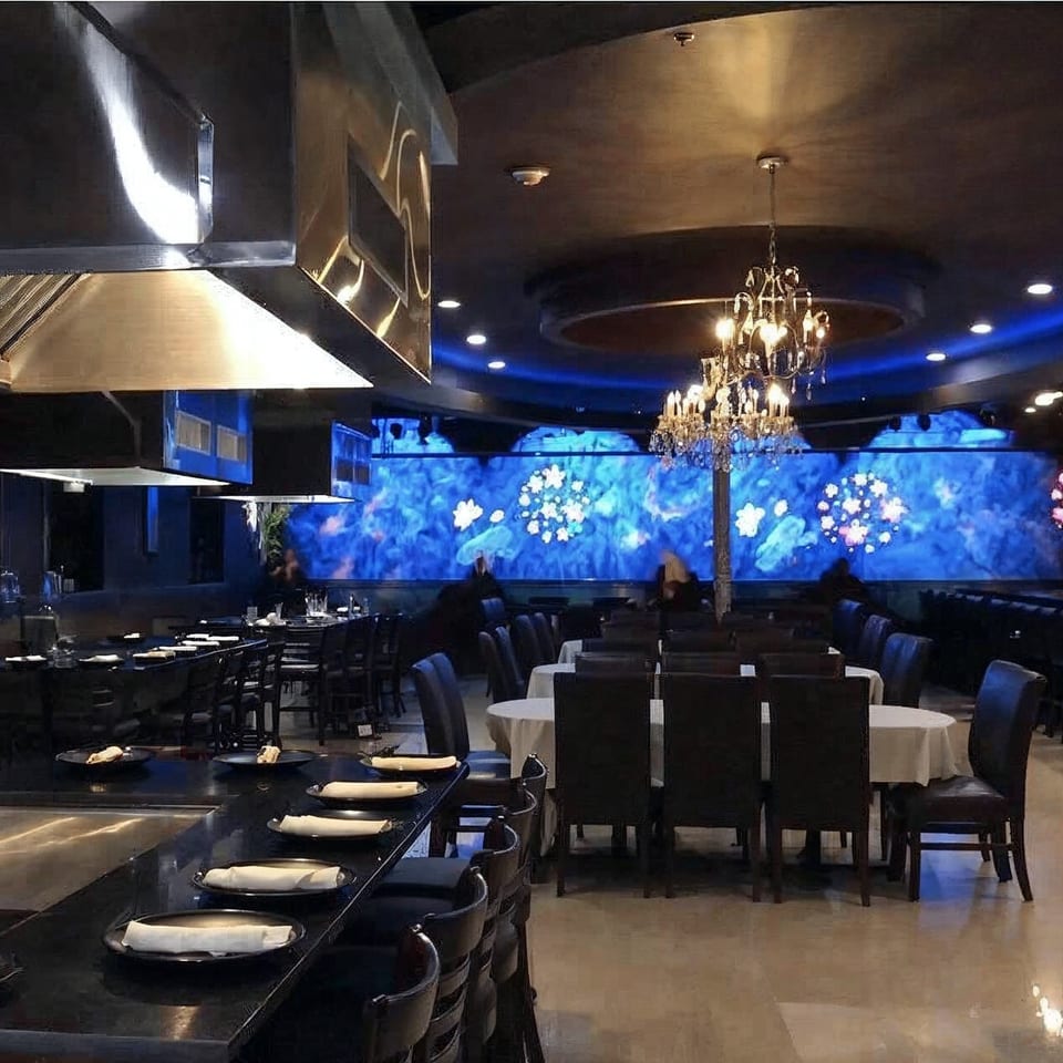 Yama Fuji restaurant interior with hibachi tables, dining tables, and a blue-lit wall mural.