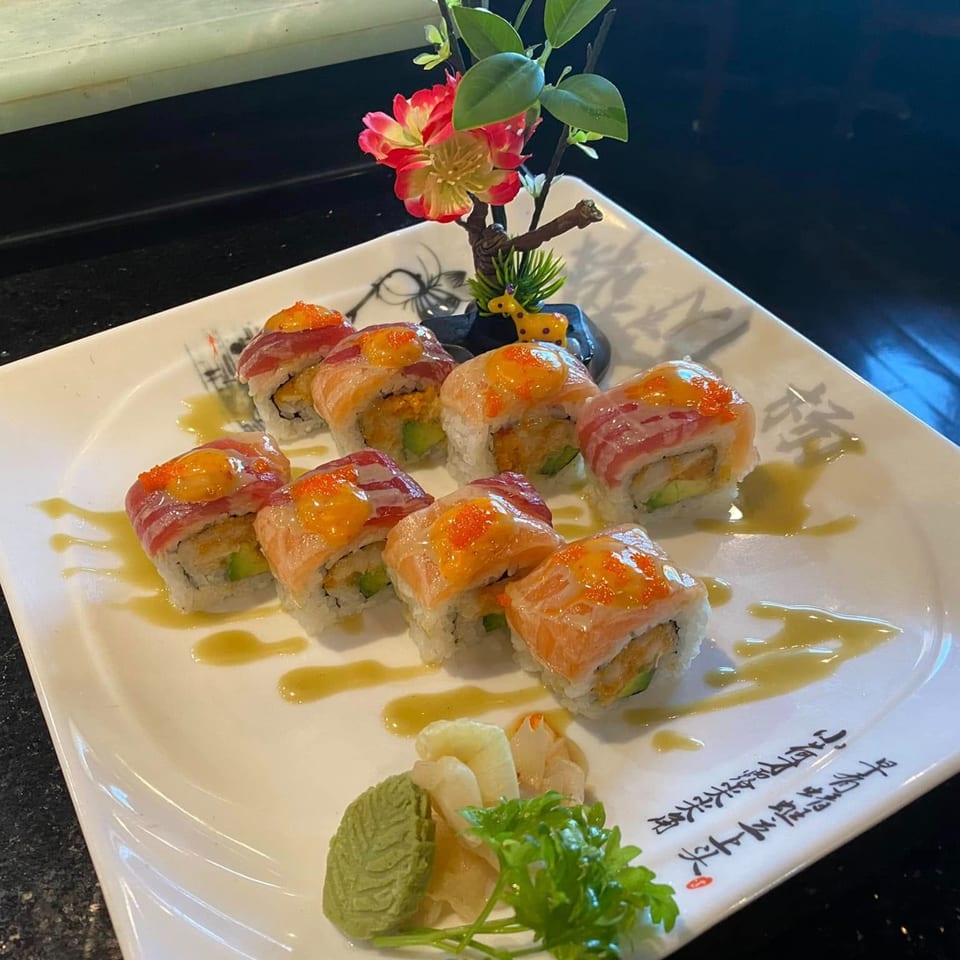 Yama Fuji sushi rolls with salmon, tuna, avocado, and roe, garnished with wasabi and ginger.